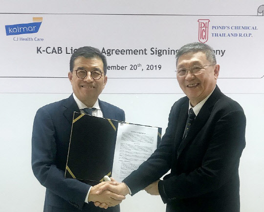 강석희 씨제이헬스케어 대표(왼쪽)와 파냐 태국 폰즈사 대표가 '케이캡정 도입 계약' 체결 후 기념촬영을 하고 있다.   씨제이헬스케어 제공